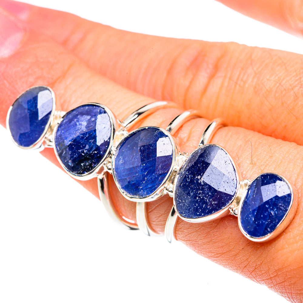 Five oval blue gemstone sterling silver rings on finger, split shank style
