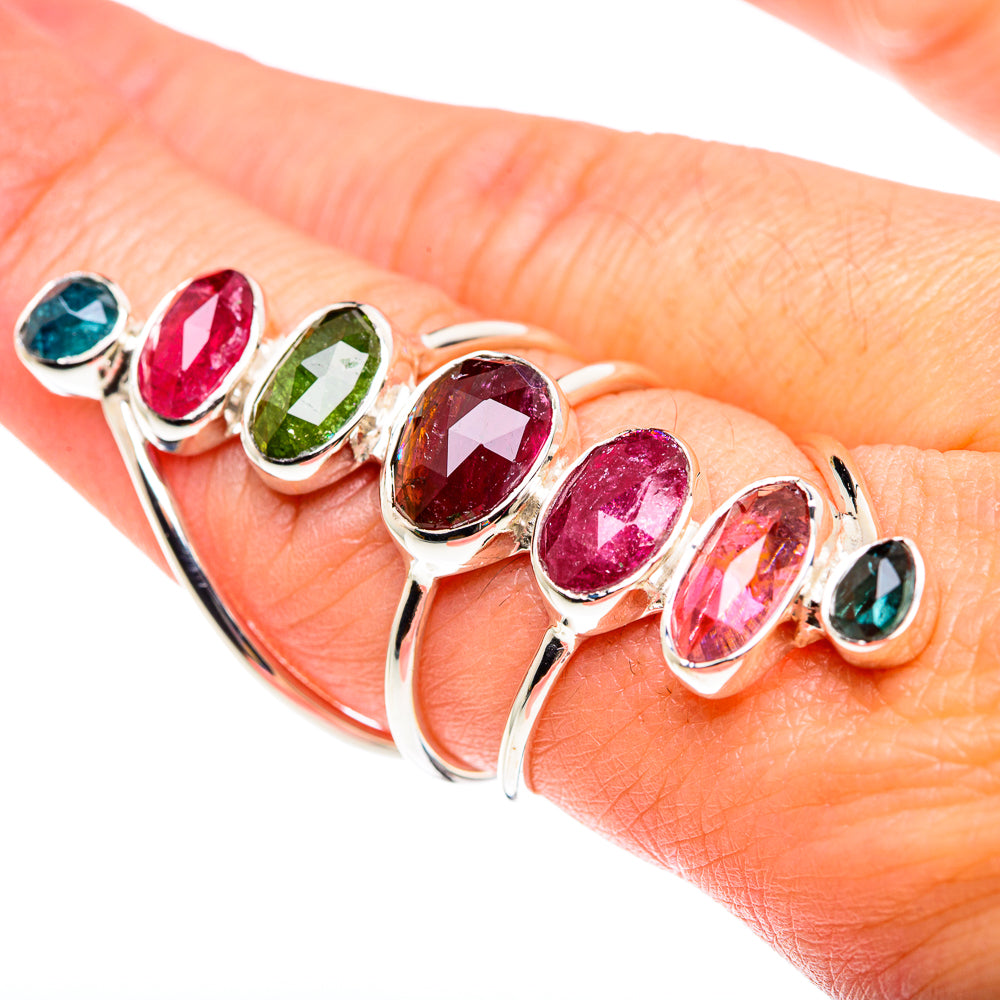 Silver ring with oval pink, green, and blue gemstones on open bands