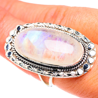 Oval moonstone ring on finger in 925 silver with dark blue accent stones