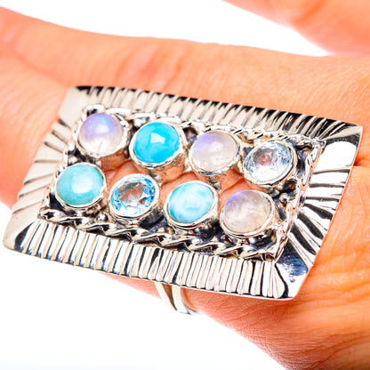 Sterling silver square ring with blue and white oval gemstones on finger, ribbed edge
