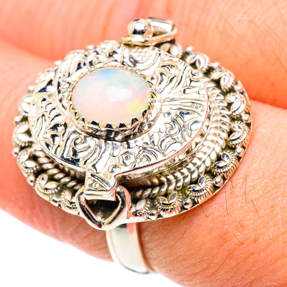 Opal gemstone sterling silver ring with ornate filigree and a round iridescent stone top