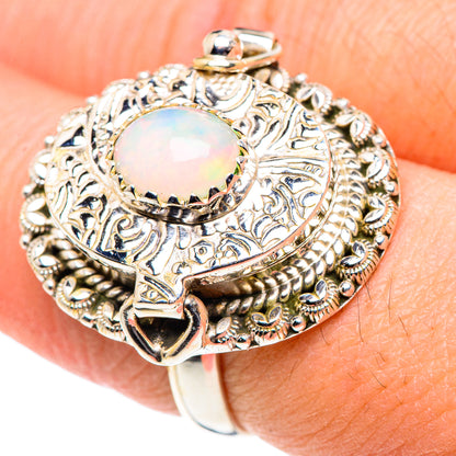 Opal gemstone sterling silver ring with ornate filigree and a round iridescent stone top