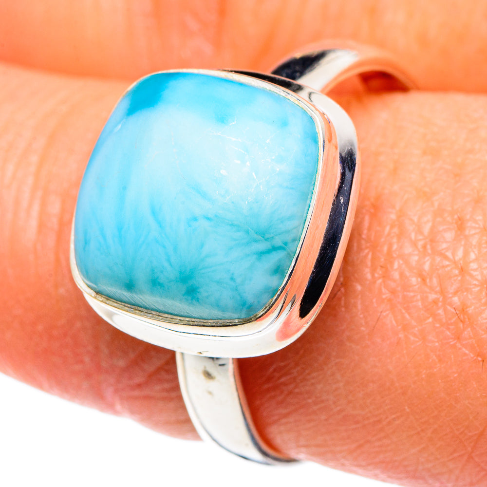 Turquoise oval larimar ring with polished sterling silver bezel, close-up on finger