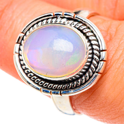 Sterling silver opal ring with oval cabochon opal and rope-style halo bezel detail