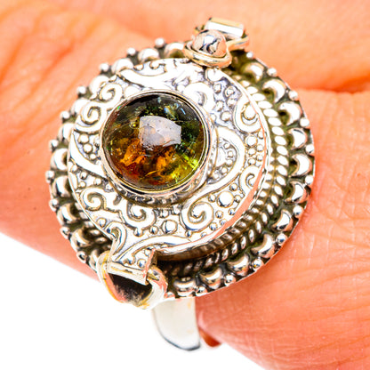 925 sterling silver ring on finger with large oval green gemstone and engraved scrollwork