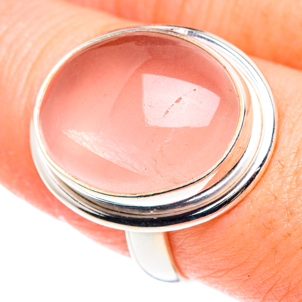 Rose quartz oval cabochon ring on finger, sterling silver triple band