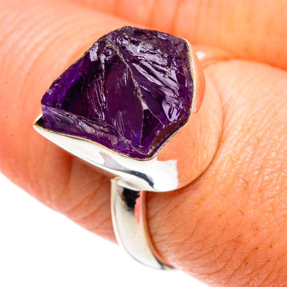Sterling silver ring with rough purple amethyst stone, faceted top and open band.