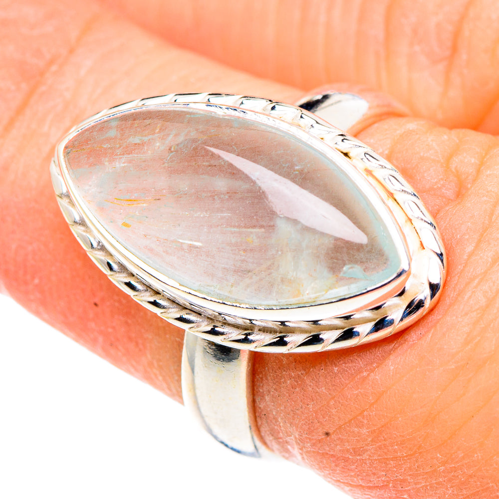 Oval aquamarine cabochon ring on finger, detailed twisted silver frame