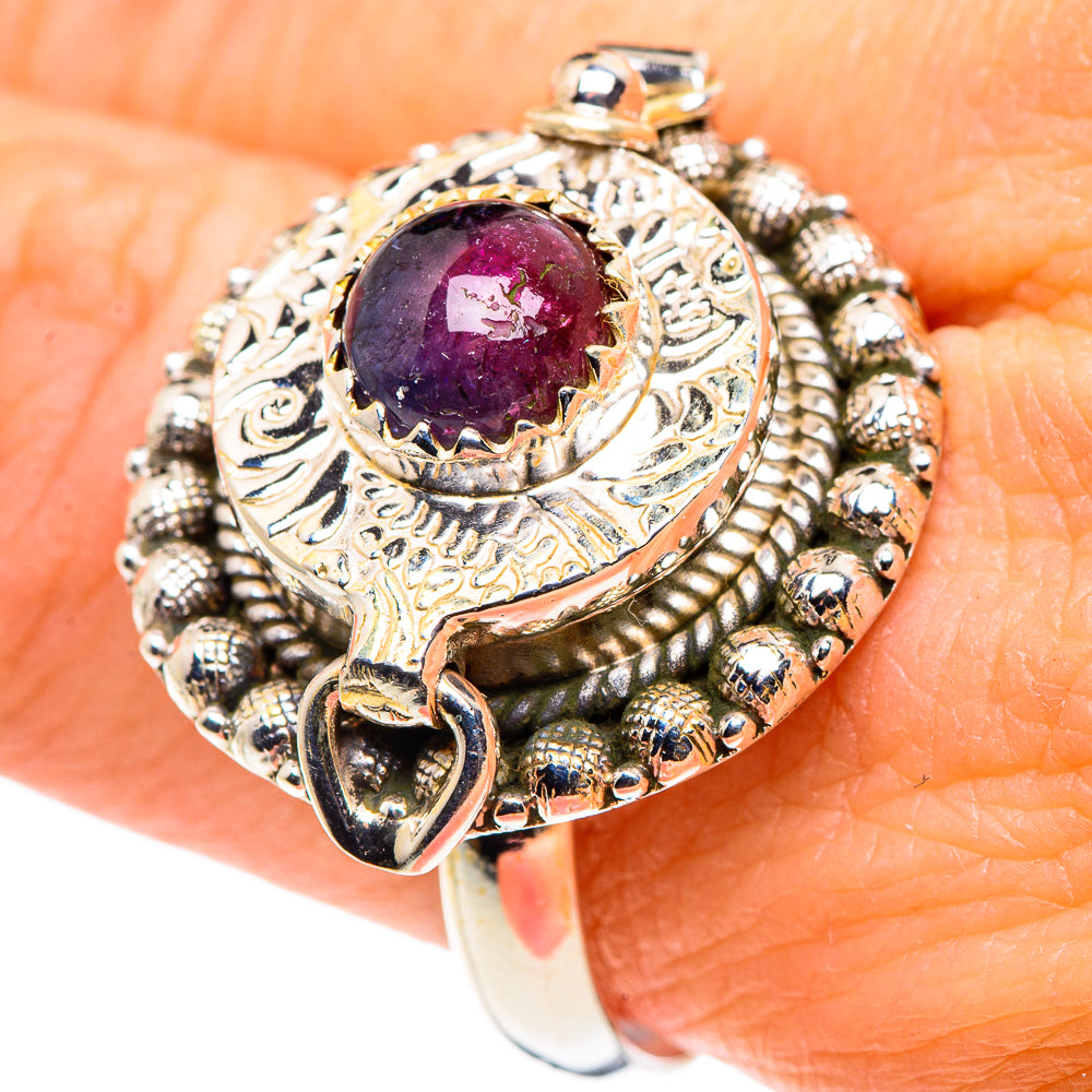 Sterling silver ring on finger with purple-pink tourmaline oval and textured snake-like band