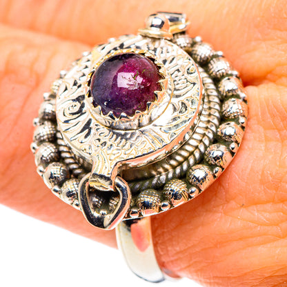 Sterling silver ring on finger with purple-pink tourmaline oval and textured snake-like band