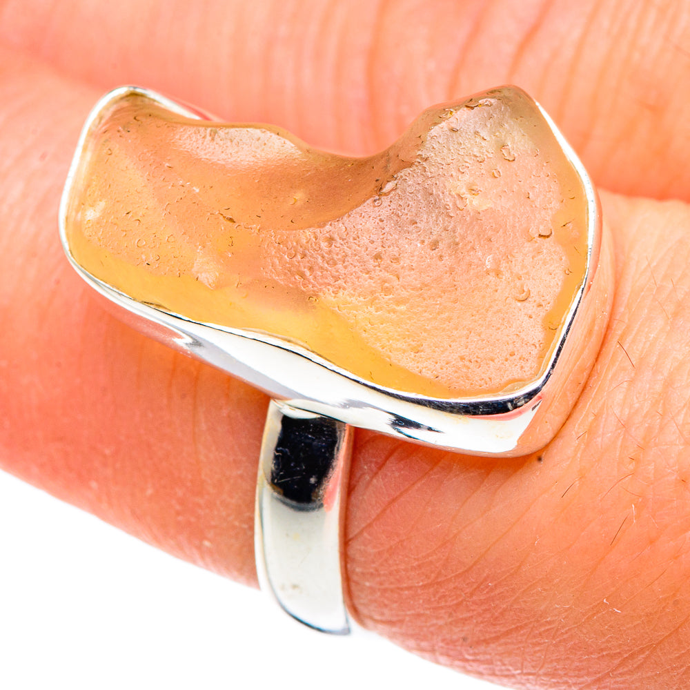 Heart-shaped sterling silver ring with yellow glass, side view on finger