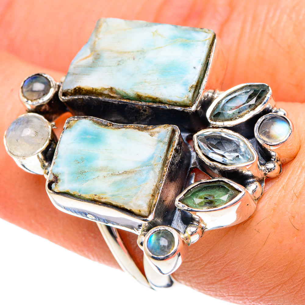 Sterling silver ring on hand with two large light-blue rectangular stones and mixed blue gems