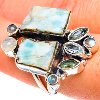 Sterling silver ring on hand with two large light-blue rectangular stones and mixed blue gems