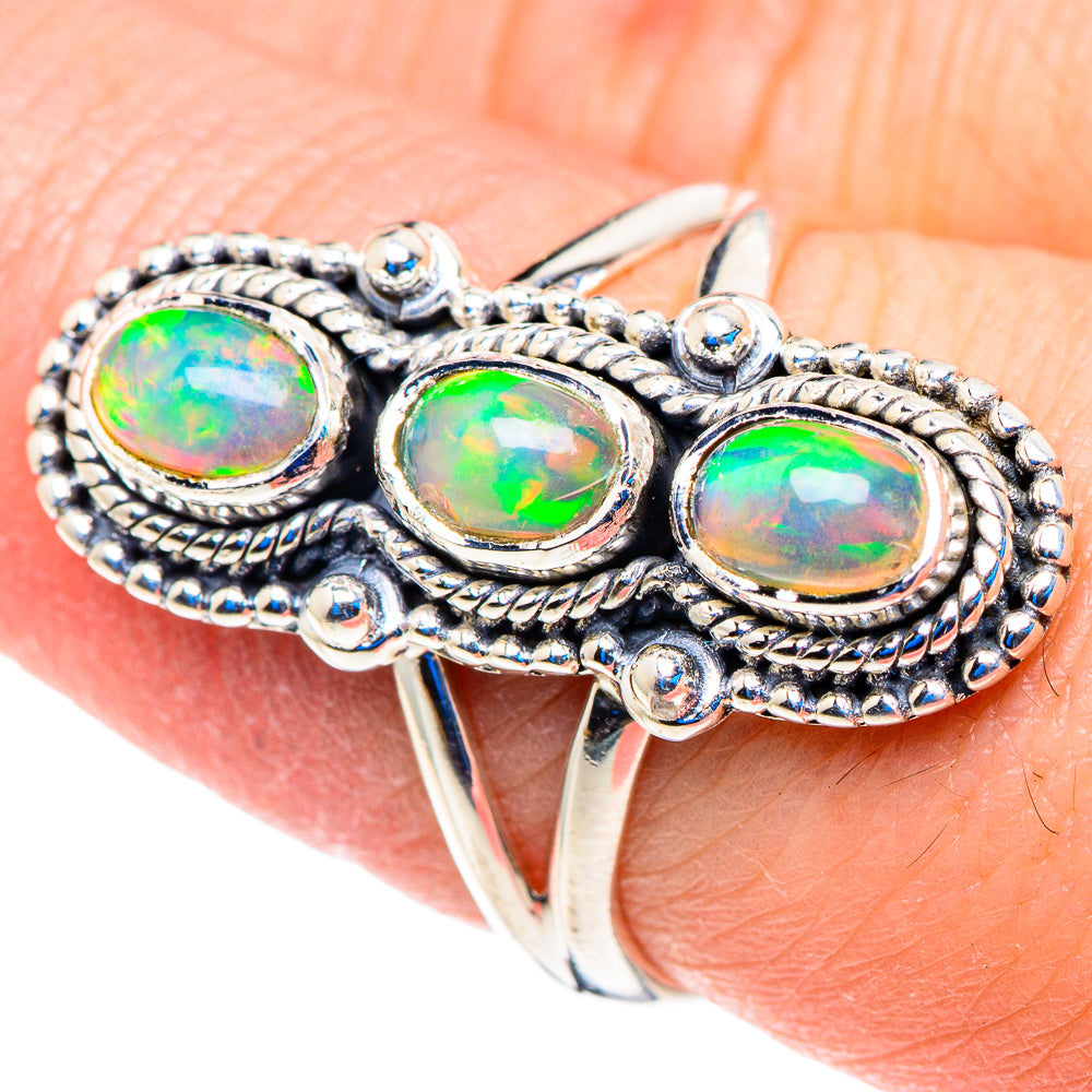 Silver opal ring with three oval opal cabochons and beaded metal border, close-up