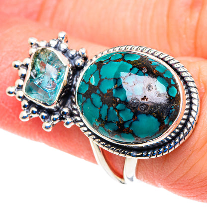 Turquoise cabochon silver ring with oval face, etched border, and blue halo stones
