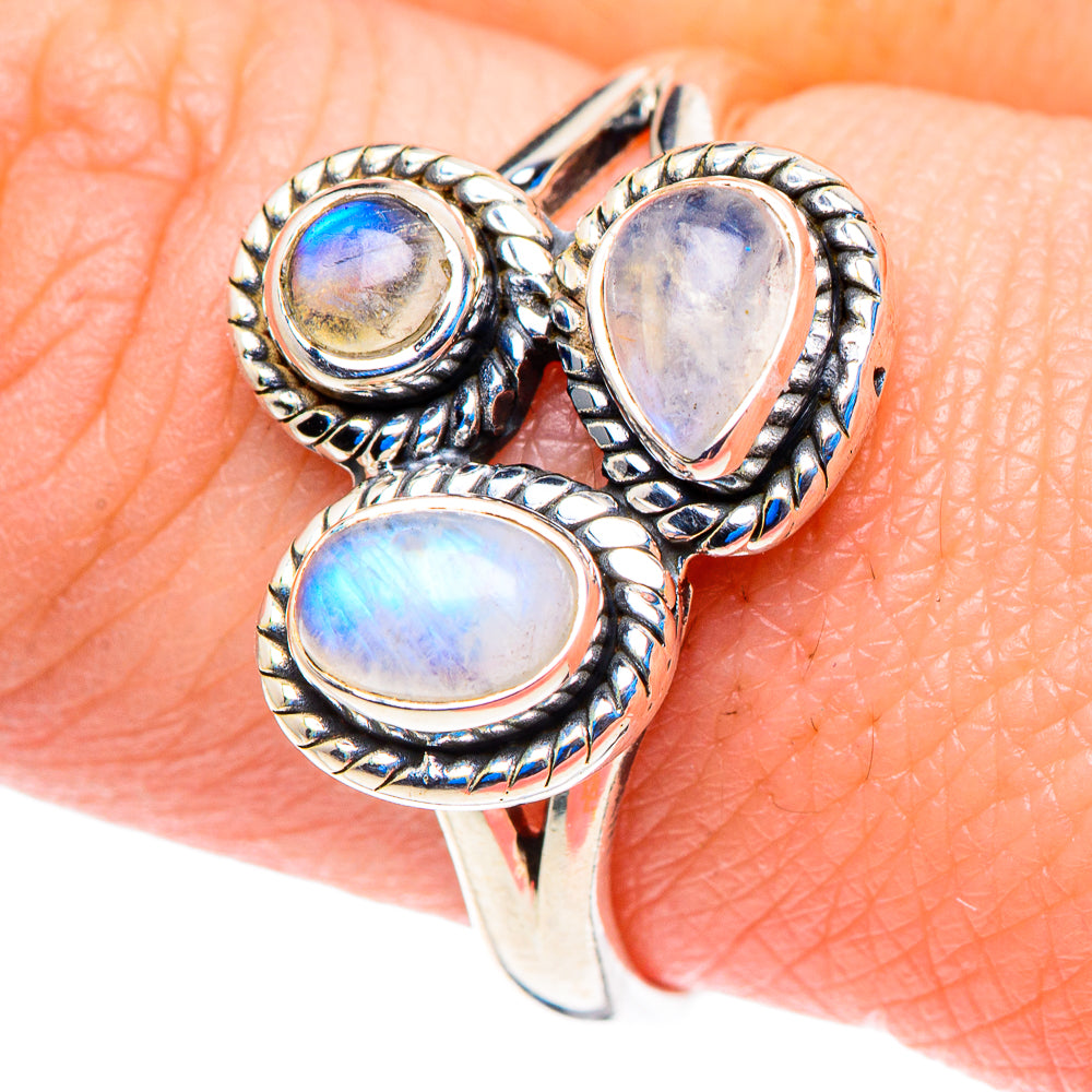 Sterling silver ring with oval and teardrop blue-green cabochons on finger, filigree