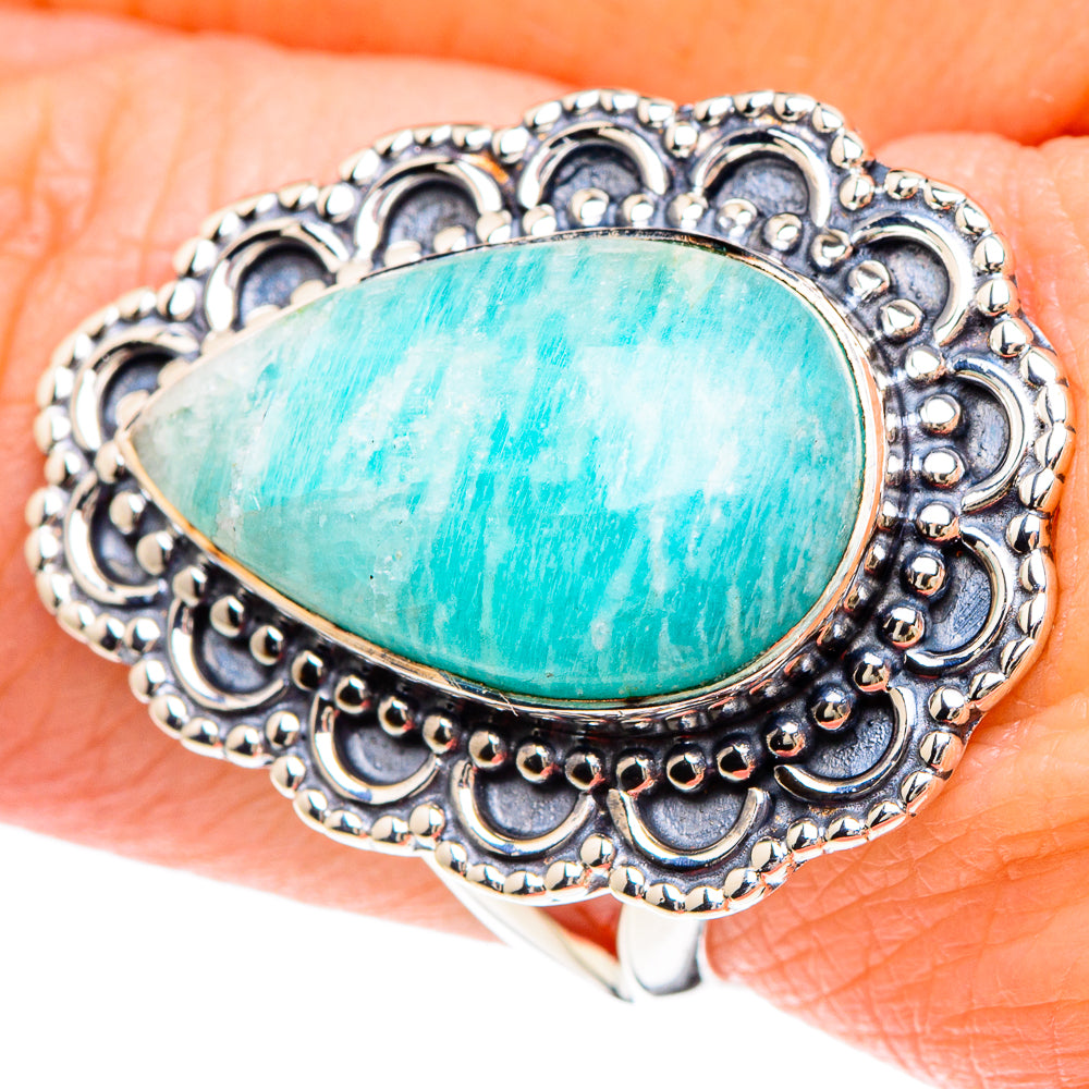 Sterling silver larimar teardrop ring with ornate filigree bezel, worn on finger