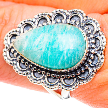 Sterling silver larimar teardrop ring with ornate filigree bezel, worn on finger