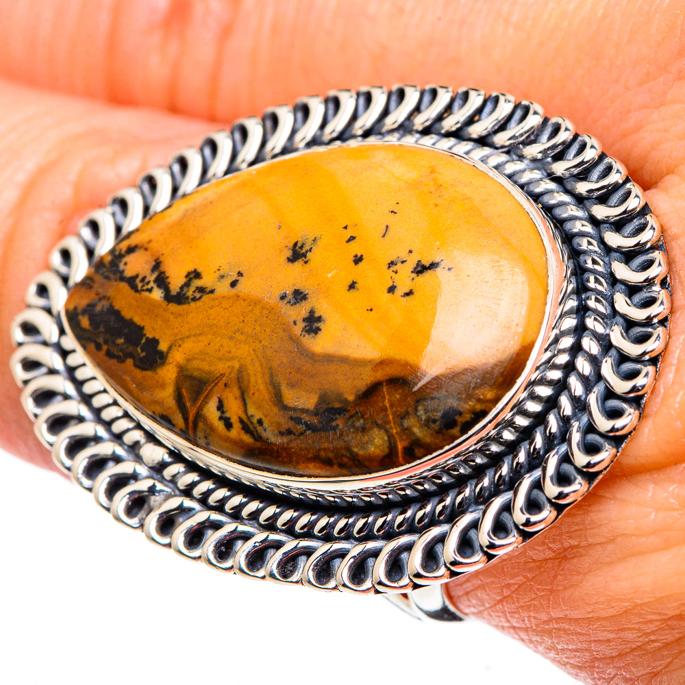 Picture jasper oval ring on finger, silver-toned bezel with dark speckled orange stone