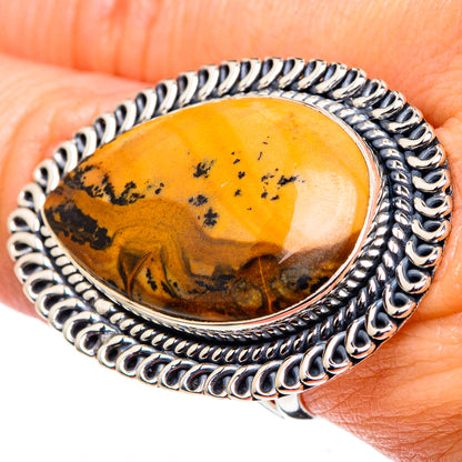 Picture jasper oval ring on finger, silver-toned bezel with dark speckled orange stone