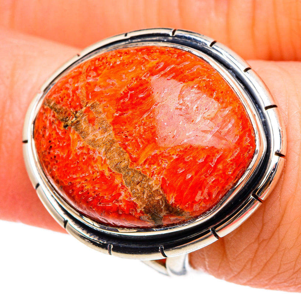 Oval sterling silver ring with orange sponge coral cabochon in dark bezel