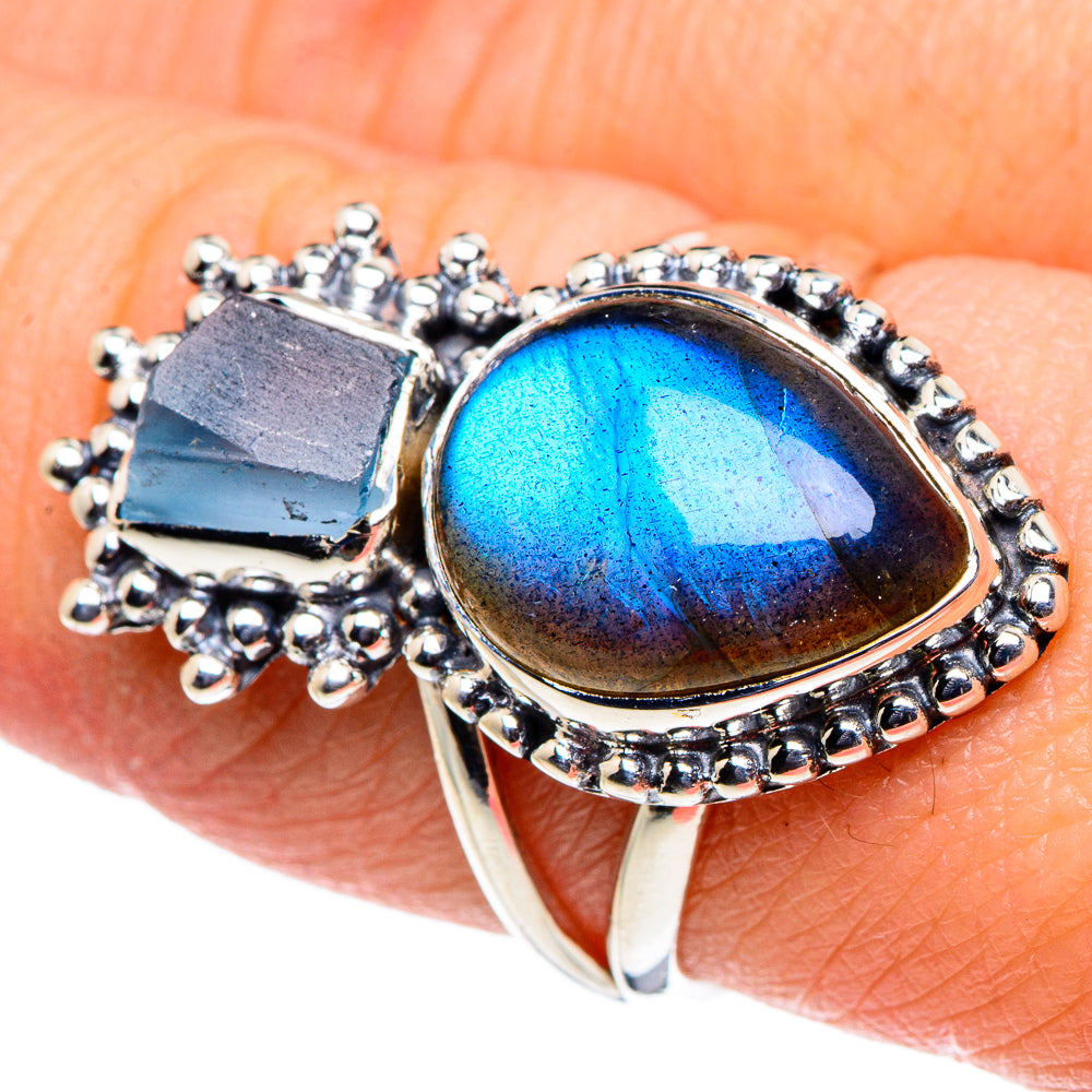 Sterling silver ring with oval blue gemstone and beaded halo, openwork border