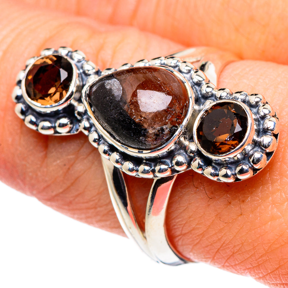 Sterling silver ring with oval smoky gemstone and two round dark stones on beaded mounts
