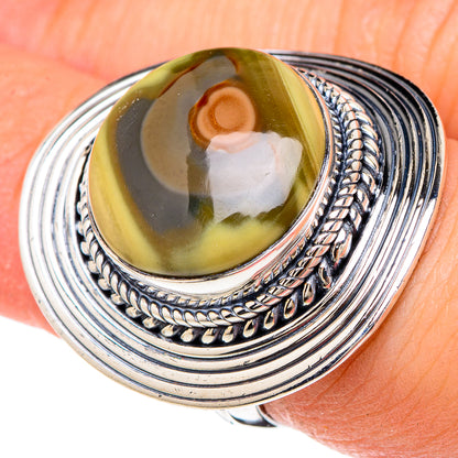 Sterling silver oval jasper cabochon ring with rope-style bezel, worn on finger