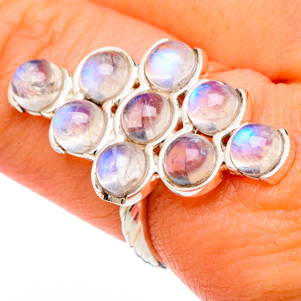 Oval rainbow moonstone cabochon cluster ring in sterling silver, shown on hand