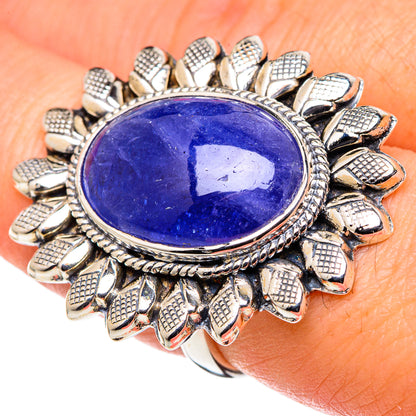 Oval blue gemstone ring with sterling-silver sunburst prongs on hand