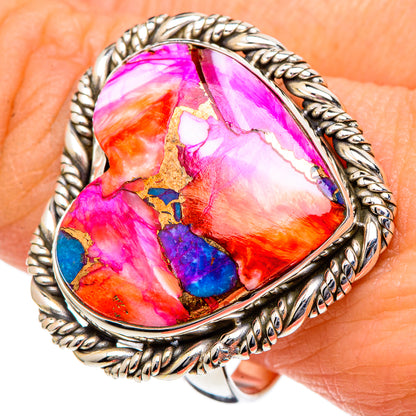 Sterling silver heart-shaped ring close-up with bright pink orange blue gemstone and braided border