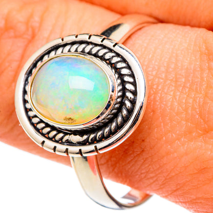 Sterling silver opal ring with round iridescent green center and ornate split-bezel band