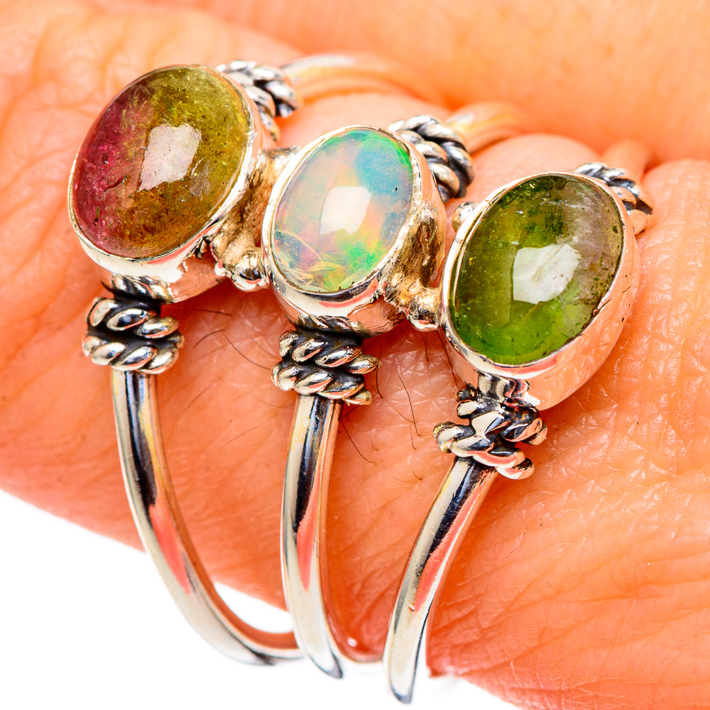 Oval gemstone silver ring with green, iridescent opal, and yellow-green stones