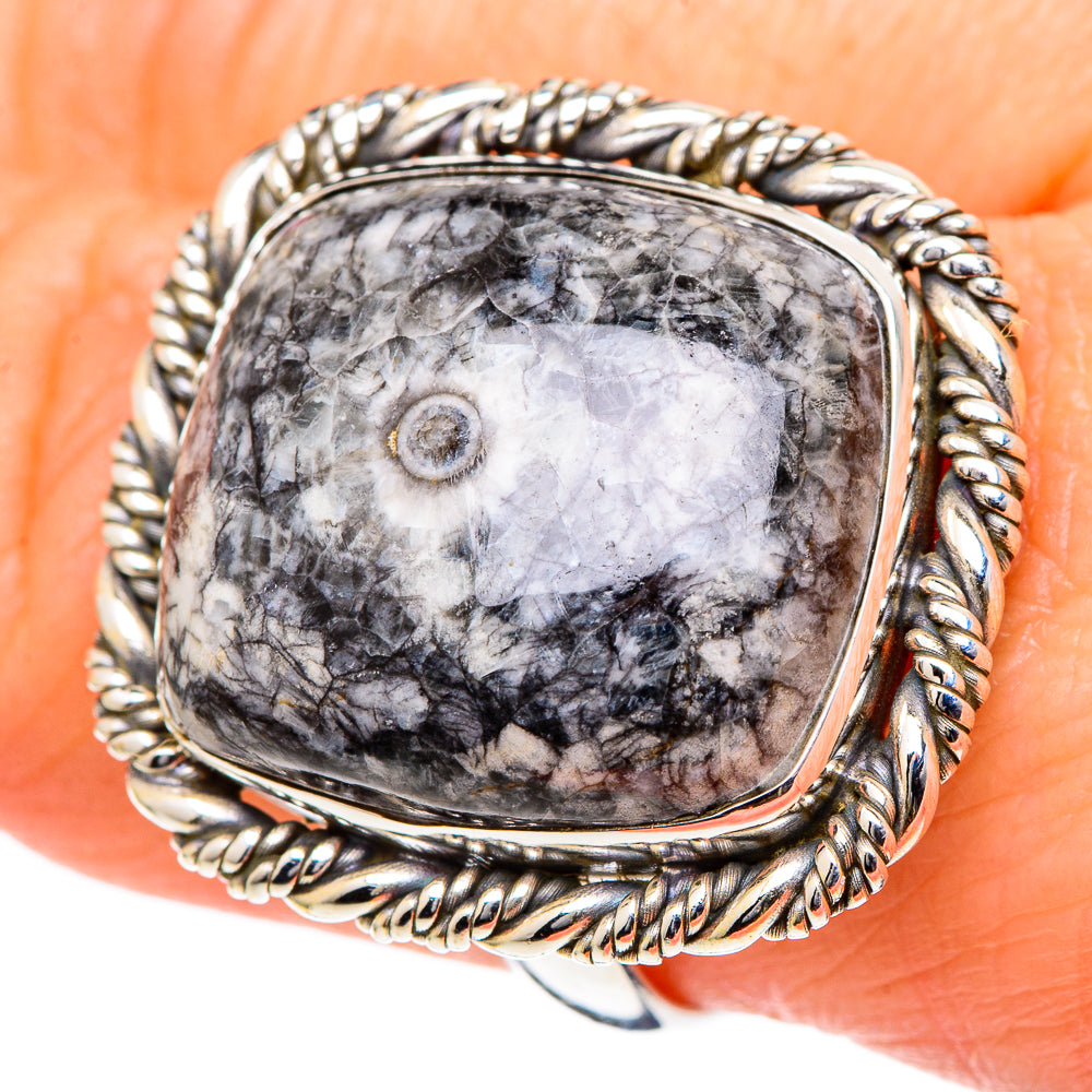 Large oval goniatite fossil ring on hand, silver rope bezel with black-and-white patterned stone.