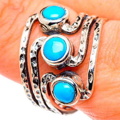 Turquoise cabochon statement ring on hand, three blue stones in silver scrollwork