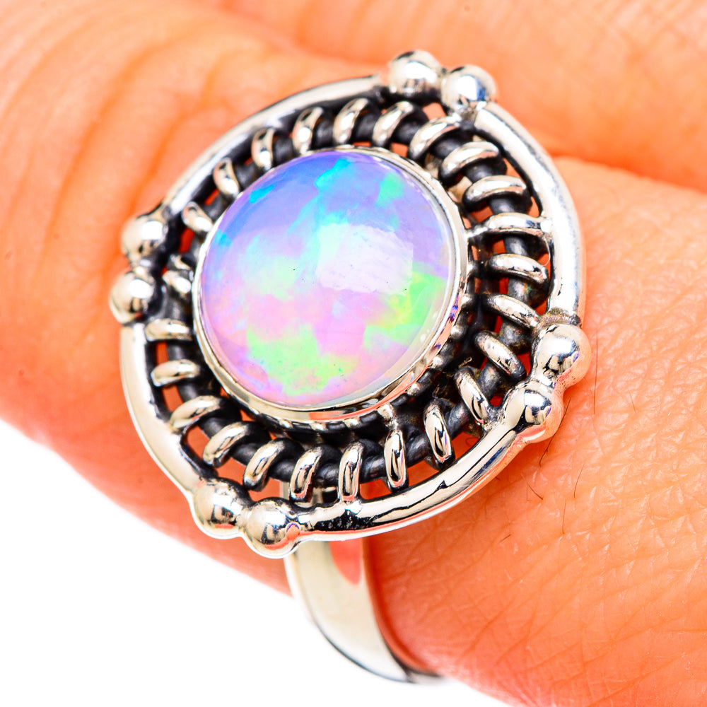 Sterling silver opal ring with round bezel and ornate side links