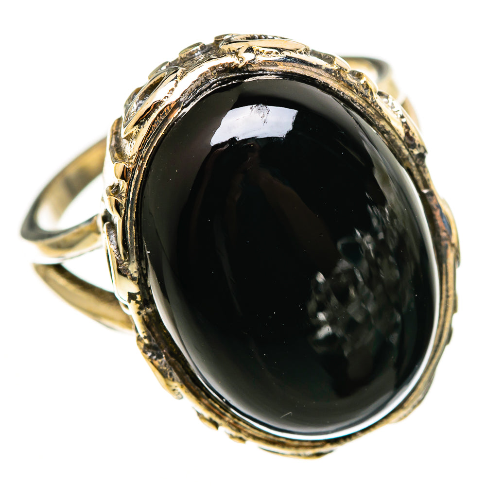 Black onyx oval ring with ornate gold-tone bezel, sterling silver band