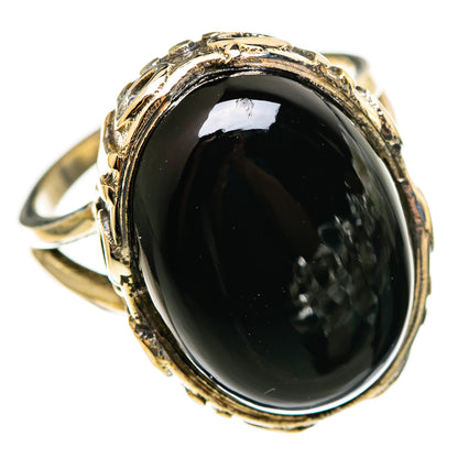 Black onyx oval ring with ornate gold-tone bezel, sterling silver band