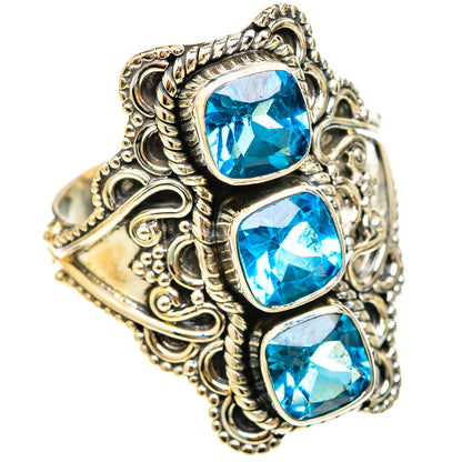 Sterling silver ring with three blue cushion-cut gemstones, detailed scrolling filigree band