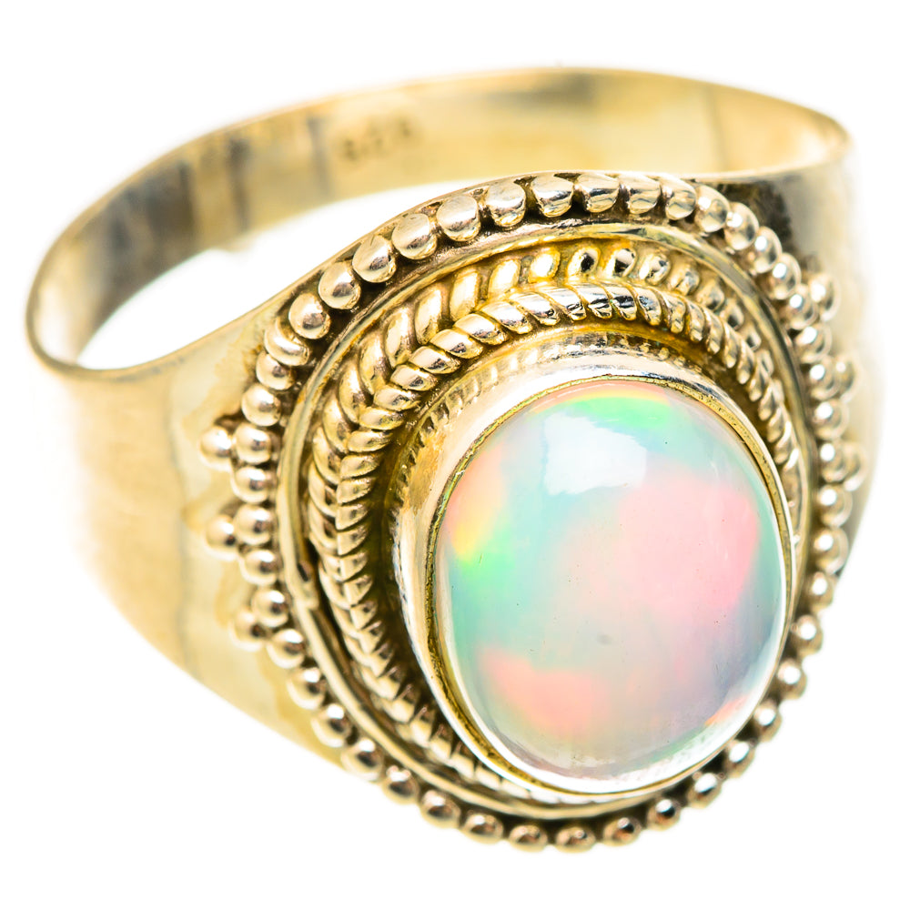 Gold-tone oval opal ring with raised bezel and beaded border, size 9.25