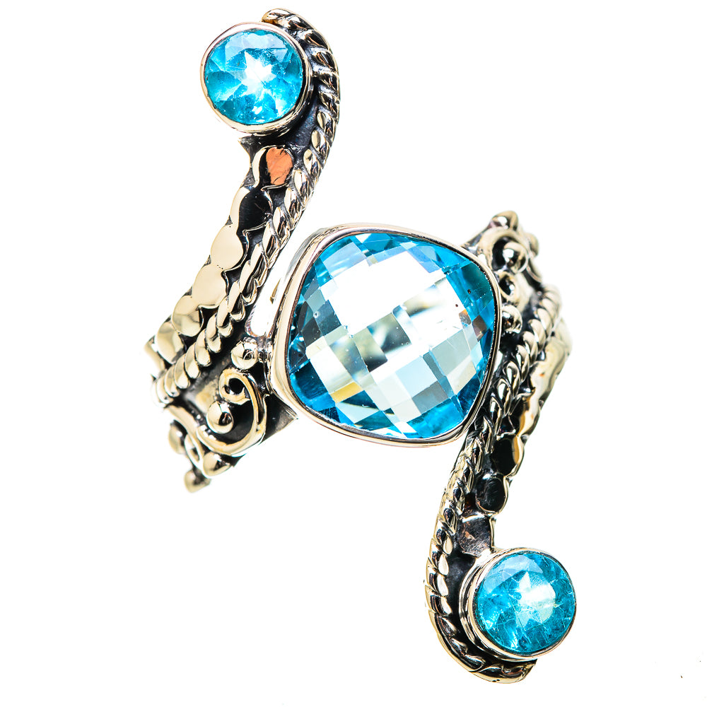 Openwork metal ring with large blue oval center stone and two small blue side stones