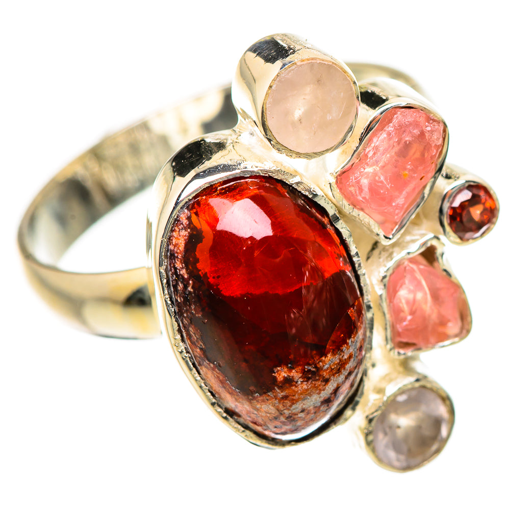 Gold-tone ring with large oval red gemstone and pink stone accents