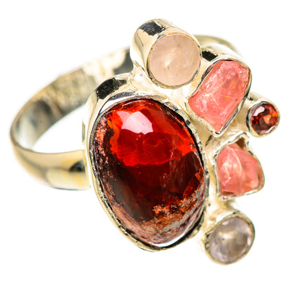 Gold-tone ring with large oval red gemstone and pink stone accents