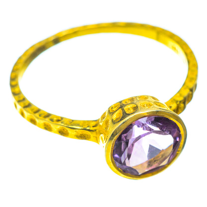 Faceted amethyst ring in gold tone with textured band and purple oval gemstone view