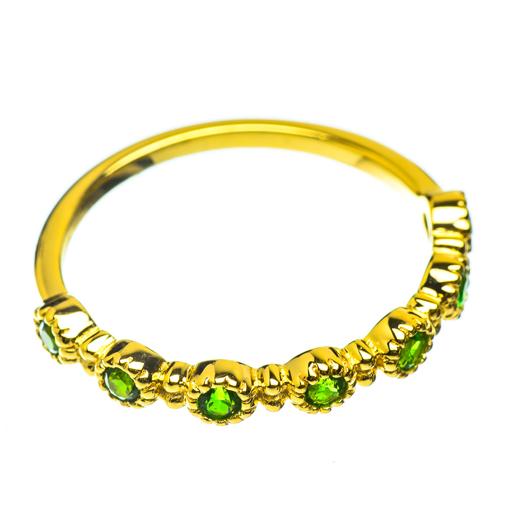 Gold-plated ring with a row of green gemstones around the band
