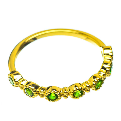 Gold-plated ring with a row of green gemstones around the band