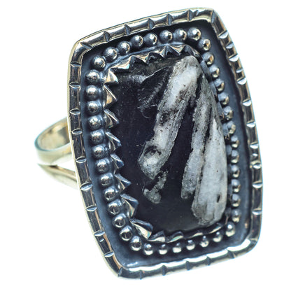 Silver oval stone ring with raised bead bezel and visible band from side angle