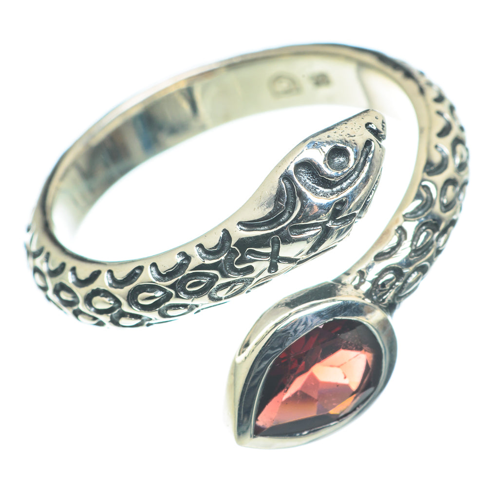 Ornate silver band ring with red teardrop garnet and open scrollwork top
