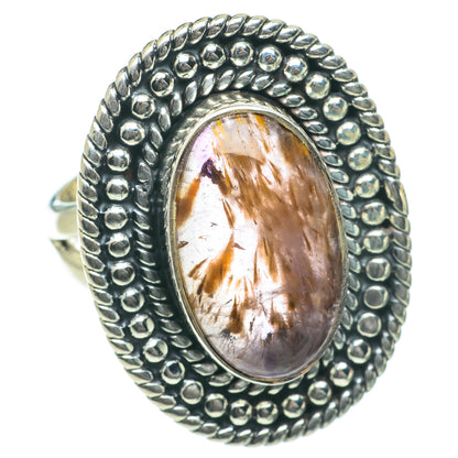 Sterling silver ring with oval gemstone cabochon, golden inclusions, and bead bezel