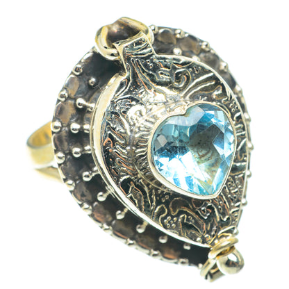 Heart-shaped blue gemstone poison ring in silver with ornate filigree and raised border